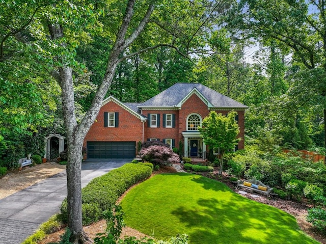 colonial-style house with a garage, a front yard, driveway, and brick siding