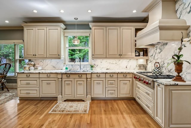 kitchen featuring a sink, cream cabinets, stainless steel gas stovetop, and custom exhaust hood