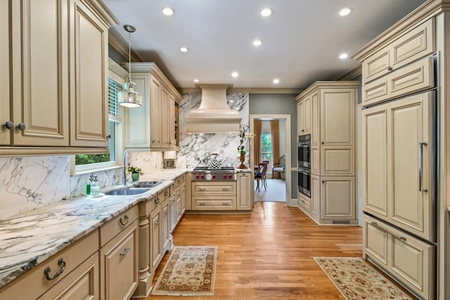 kitchen featuring decorative backsplash, cream cabinets, light stone countertops, a sink, and recessed lighting