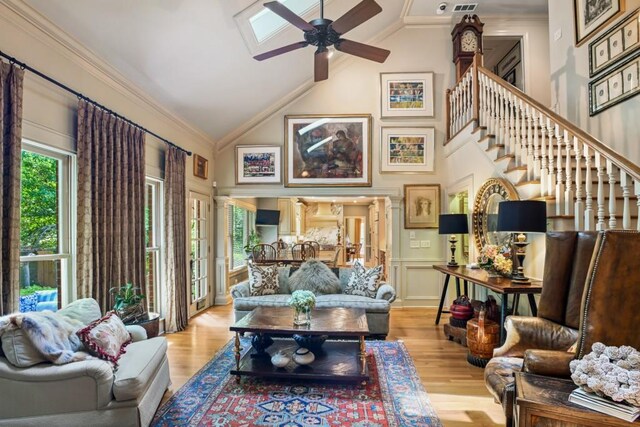 living area with crown molding, a ceiling fan, high vaulted ceiling, and wood finished floors