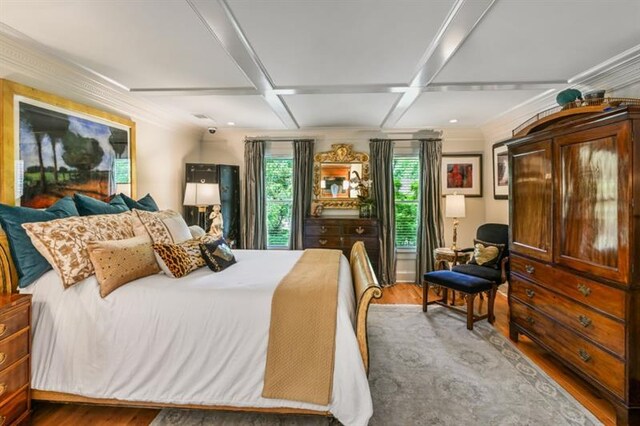 bedroom featuring multiple windows, coffered ceiling, and wood finished floors