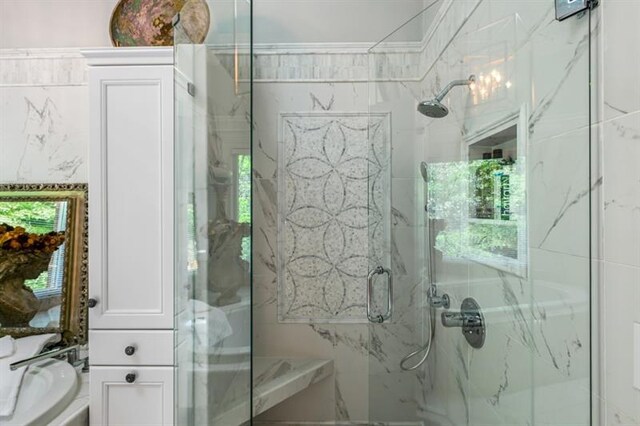 bathroom featuring a marble finish shower