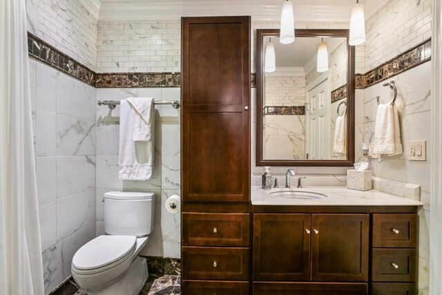 bathroom featuring crown molding, tile walls, vanity, and toilet
