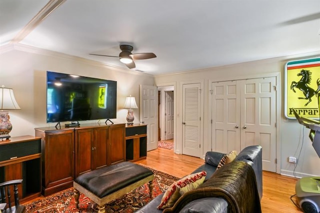 living area featuring crown molding, ceiling fan, and light wood finished floors