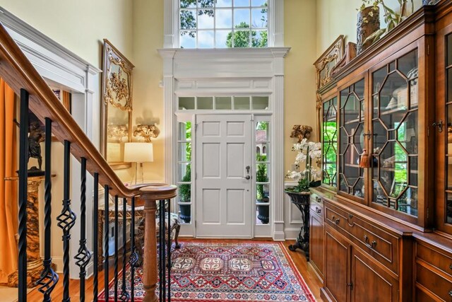 entryway featuring a towering ceiling and wood finished floors