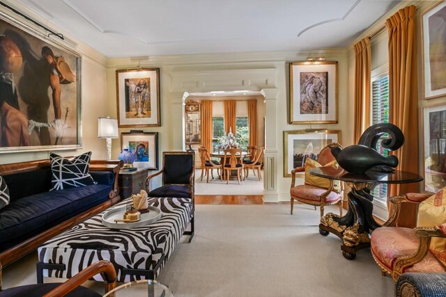 living area with carpet floors and ornamental molding