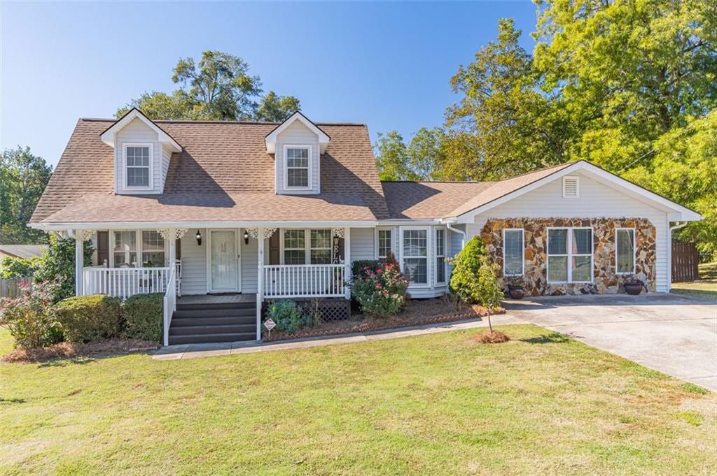 cape cod-style house with covered porch and a front lawn