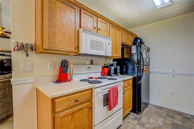 kitchen with white appliances, a textured ceiling, stone finish floor, light countertops, and baseboards