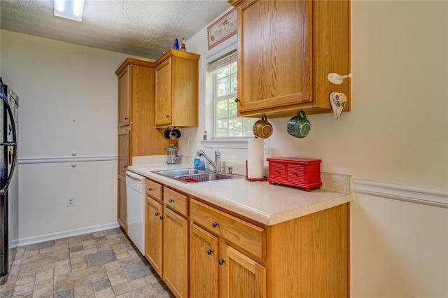 kitchen featuring a sink, brown cabinetry, a textured ceiling, dishwasher, and light countertops