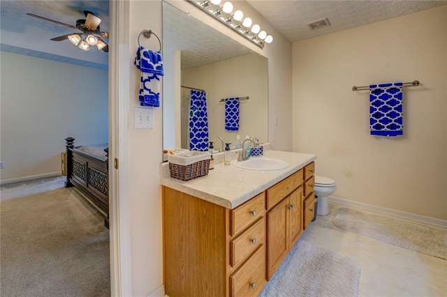 full bathroom with vanity, toilet, baseboards, and a ceiling fan