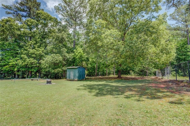 view of yard featuring an outdoor structure, fence, and a shed