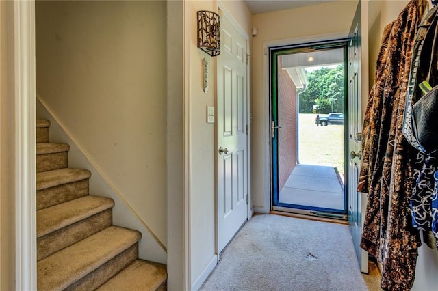 entryway with light colored carpet and stairs