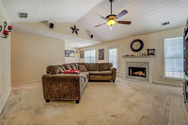 living area with light colored carpet, visible vents, baseboards, and a ceiling fan