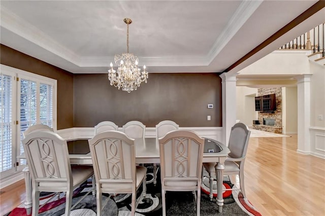 3565 Hickory Branch Trl, Suwanee, GA 30024 - dining area with a chandelier, a raised ceiling, light wood-style floors, ornamental molding, and a decorative wall