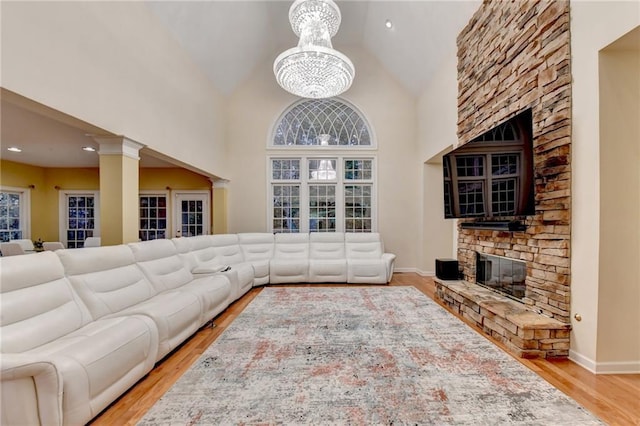 3565 Hickory Branch Trl, Suwanee, GA 30024 - living room featuring a fireplace, wood finished floors, a chandelier, baseboards, and high vaulted ceiling