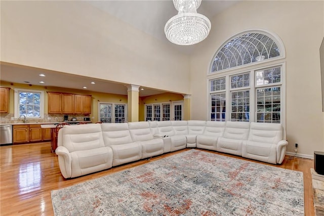 3565 Hickory Branch Trl, Suwanee, GA 30024 - living area featuring high vaulted ceiling, light wood finished floors, a chandelier, decorative columns, and recessed lighting