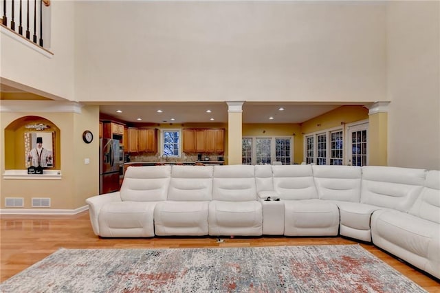 3565 Hickory Branch Trl, Suwanee, GA 30024 - living area featuring decorative columns, a towering ceiling, light wood-type flooring, baseboards, and recessed lighting