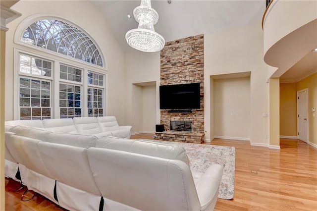 3565 Hickory Branch Trl, Suwanee, GA 30024 - living area with high vaulted ceiling, baseboards, a fireplace, light wood finished floors, and a chandelier