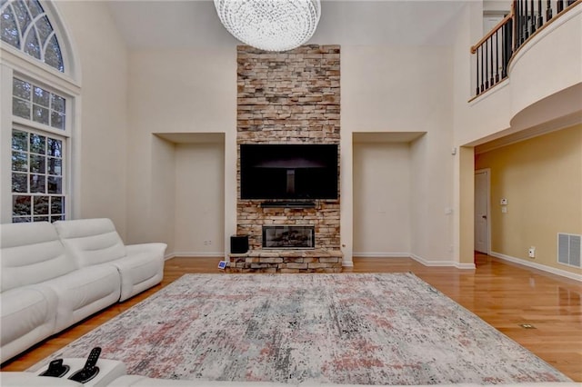 3565 Hickory Branch Trl, Suwanee, GA 30024 - living area with a high ceiling, wood finished floors, baseboards, and a fireplace