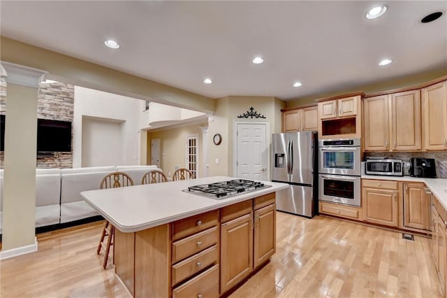 3565 Hickory Branch Trl, Suwanee, GA 30024 - kitchen featuring stainless steel appliances, a kitchen bar, a kitchen island, light countertops, and light wood-type flooring