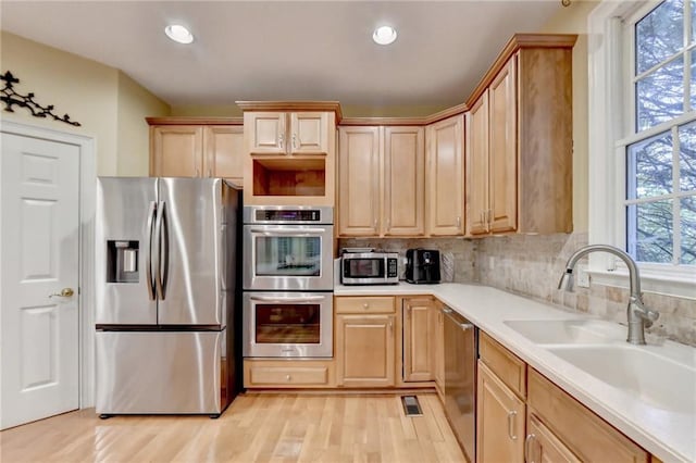 3565 Hickory Branch Trl, Suwanee, GA 30024 - kitchen with appliances with stainless steel finishes, a sink, light brown cabinets, light wood-style flooring, and light countertops
