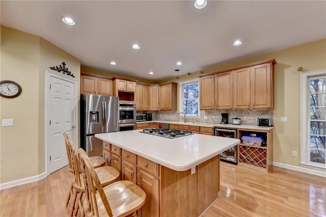 3565 Hickory Branch Trl, Suwanee, GA 30024 - kitchen with wine cooler, stainless steel appliances, baseboards, a sink, and a breakfast bar area