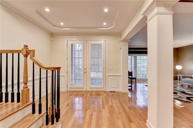 3565 Hickory Branch Trl, Suwanee, GA 30024 - foyer entrance with decorative columns, a tray ceiling, light wood-style floors, a decorative wall, and ornamental molding
