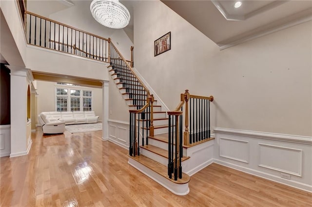 3565 Hickory Branch Trl, Suwanee, GA 30024 - stairs with wood finished floors, a decorative wall, a chandelier, wainscoting, and ornamental molding