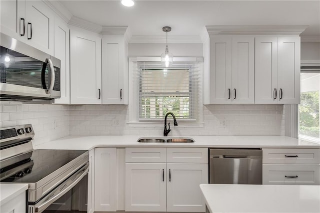 kitchen with stainless steel appliances, a sink, white cabinets, and crown molding