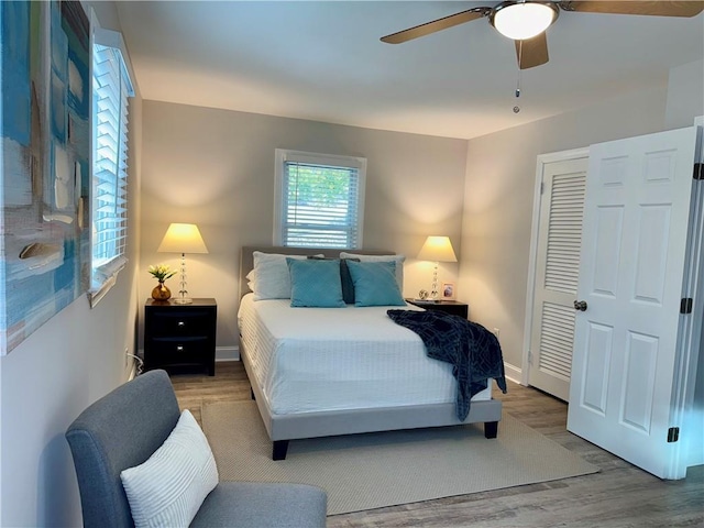 bedroom with a ceiling fan, a closet, baseboards, and wood finished floors