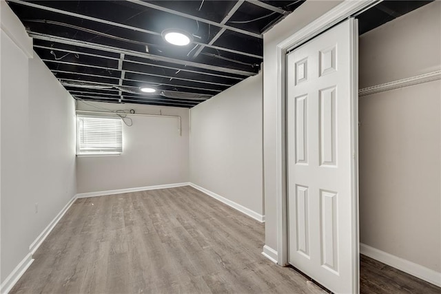 basement featuring baseboards and wood finished floors