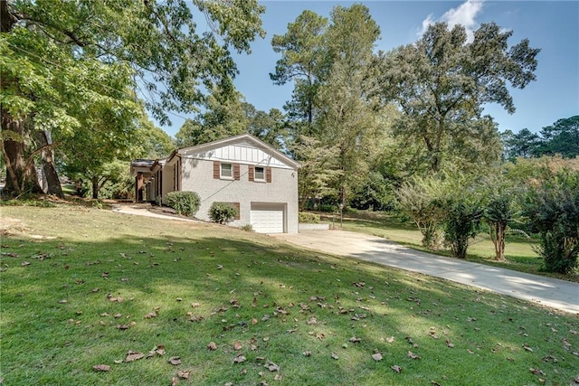 exterior space with an attached garage, brick siding, concrete driveway, and a yard