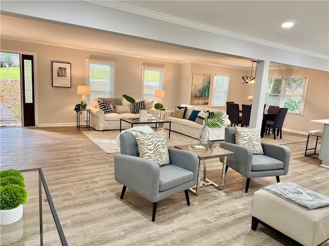 living area with light wood-style floors, plenty of natural light, and crown molding