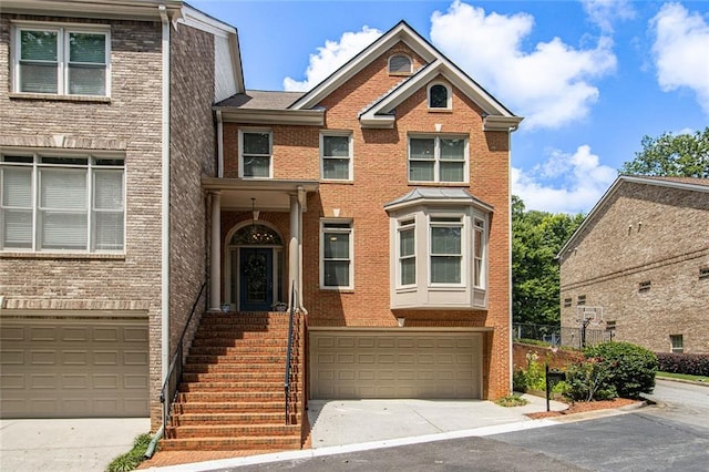 5575 Julian Pl, Atlanta, GA 30342 - townhome / multi-family property featuring an attached garage, concrete driveway, and brick siding