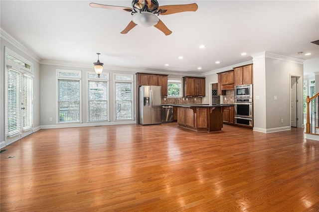 5575 Julian Pl, Atlanta, GA 30342 - kitchen featuring stainless steel appliances, open floor plan, a kitchen bar, wood finished floors, and dark countertops