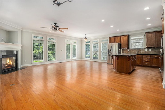 5575 Julian Pl, Atlanta, GA 30342 - kitchen featuring open floor plan, stainless steel refrigerator with ice dispenser, ornamental molding, dark countertops, and a kitchen island