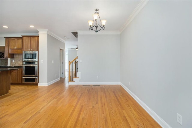 5575 Julian Pl, Atlanta, GA 30342 - kitchen with appliances with stainless steel finishes, dark countertops, a chandelier, crown molding, and backsplash