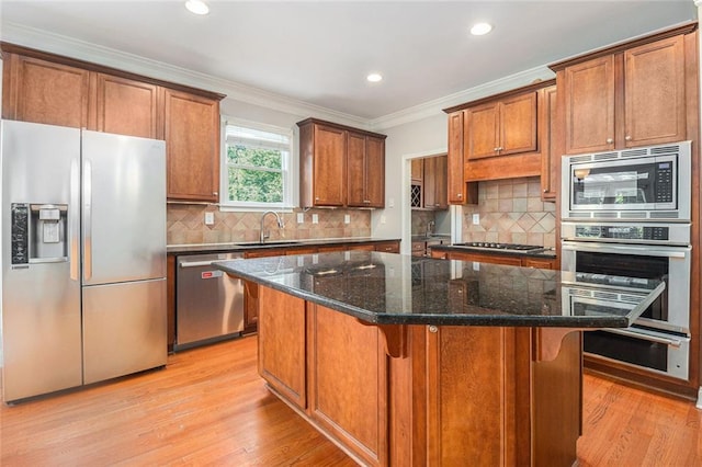 5575 Julian Pl, Atlanta, GA 30342 - kitchen with stainless steel appliances, crown molding, light wood-style flooring, recessed lighting, and a kitchen island