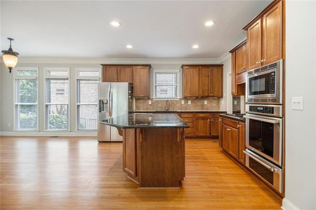 5575 Julian Pl, Atlanta, GA 30342 - kitchen featuring appliances with stainless steel finishes, a warming drawer, ornamental molding, brown cabinets, and a kitchen island