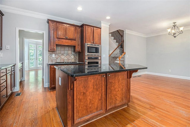 5575 Julian Pl, Atlanta, GA 30342 - kitchen with stainless steel appliances, light wood-style flooring, crown molding, a chandelier, and tasteful backsplash