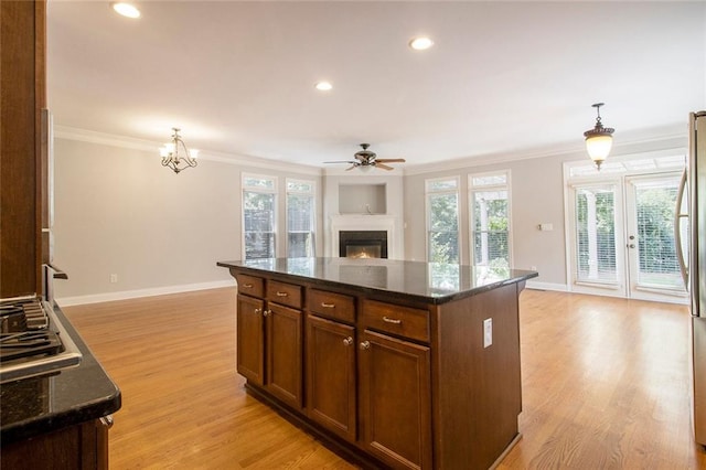 5575 Julian Pl, Atlanta, GA 30342 - kitchen featuring ornamental molding, a warm lit fireplace, light wood-type flooring, open floor plan, and a ceiling fan