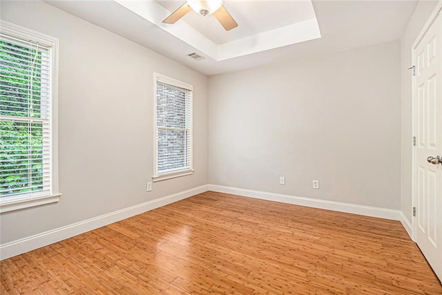 5575 Julian Pl, Atlanta, GA 30342 - spare room with light wood-style floors, healthy amount of natural light, a tray ceiling, and ceiling fan