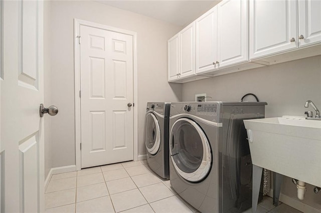 5575 Julian Pl, Atlanta, GA 30342 - laundry room featuring cabinet space, light tile patterned floors, and independent washer and dryer