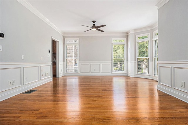 5575 Julian Pl, Atlanta, GA 30342 - unfurnished living room featuring plenty of natural light, a ceiling fan, a decorative wall, wood finished floors, and crown molding