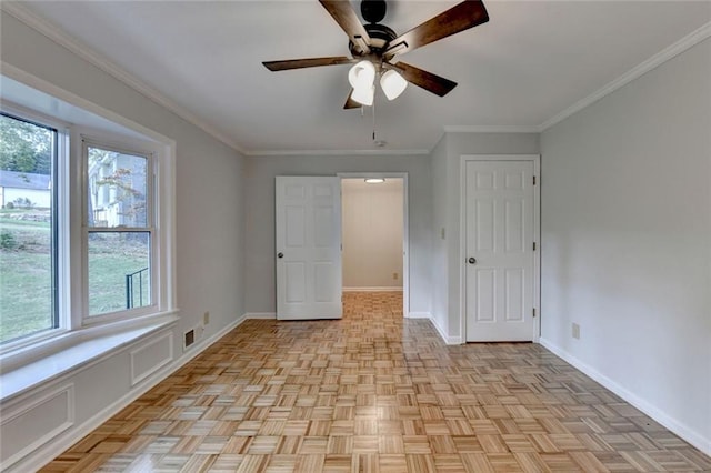 unfurnished bedroom featuring a ceiling fan, visible vents, baseboards, and crown molding