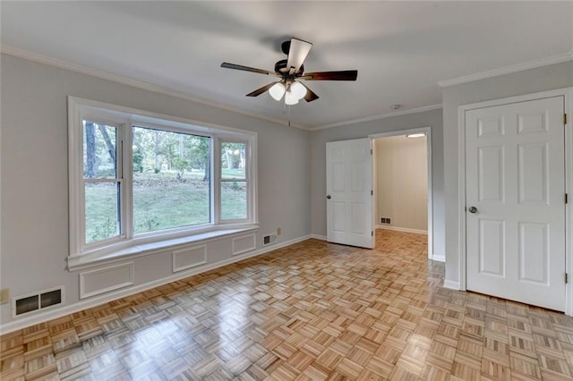 unfurnished room featuring crown molding, ceiling fan, visible vents, and baseboards