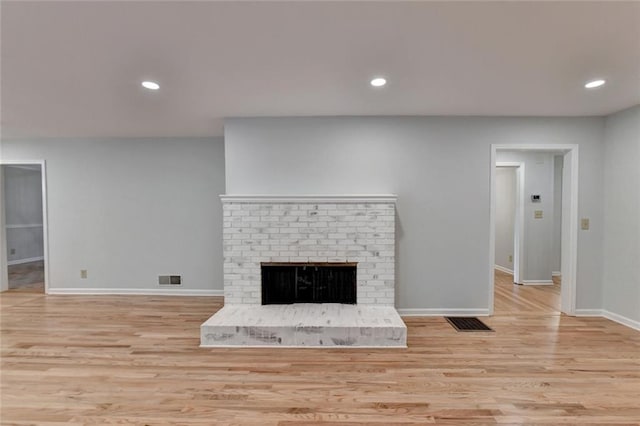 unfurnished living room with recessed lighting, a fireplace, wood finished floors, visible vents, and baseboards