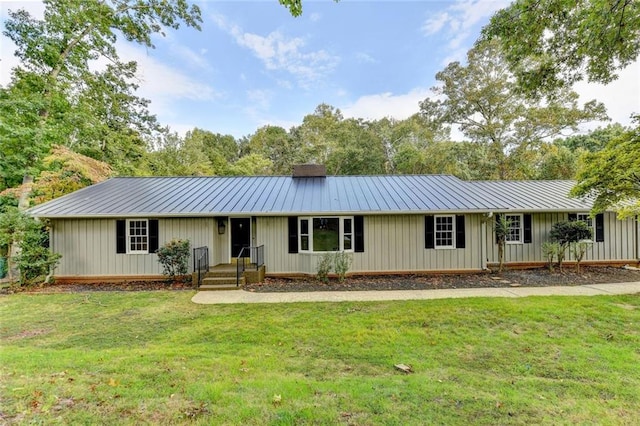 ranch-style house with metal roof, a front lawn, and a standing seam roof