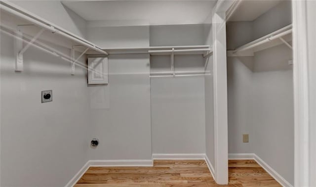 laundry room featuring laundry area, light wood-style flooring, baseboards, and electric dryer hookup