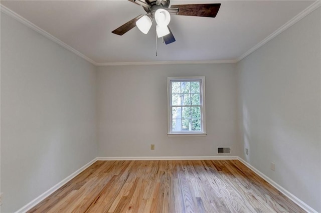 spare room featuring light wood-type flooring, baseboards, visible vents, and ornamental molding